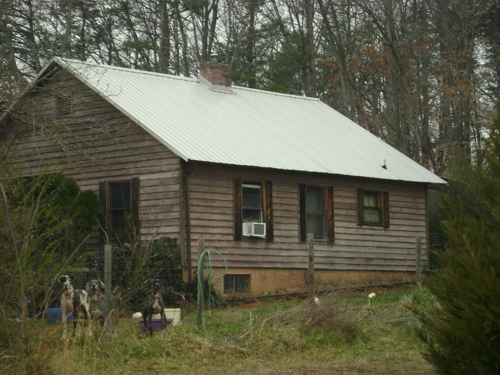 White metal roof on an old wood sided farmhouse, from a Metal Roof Installation job in Greenfield